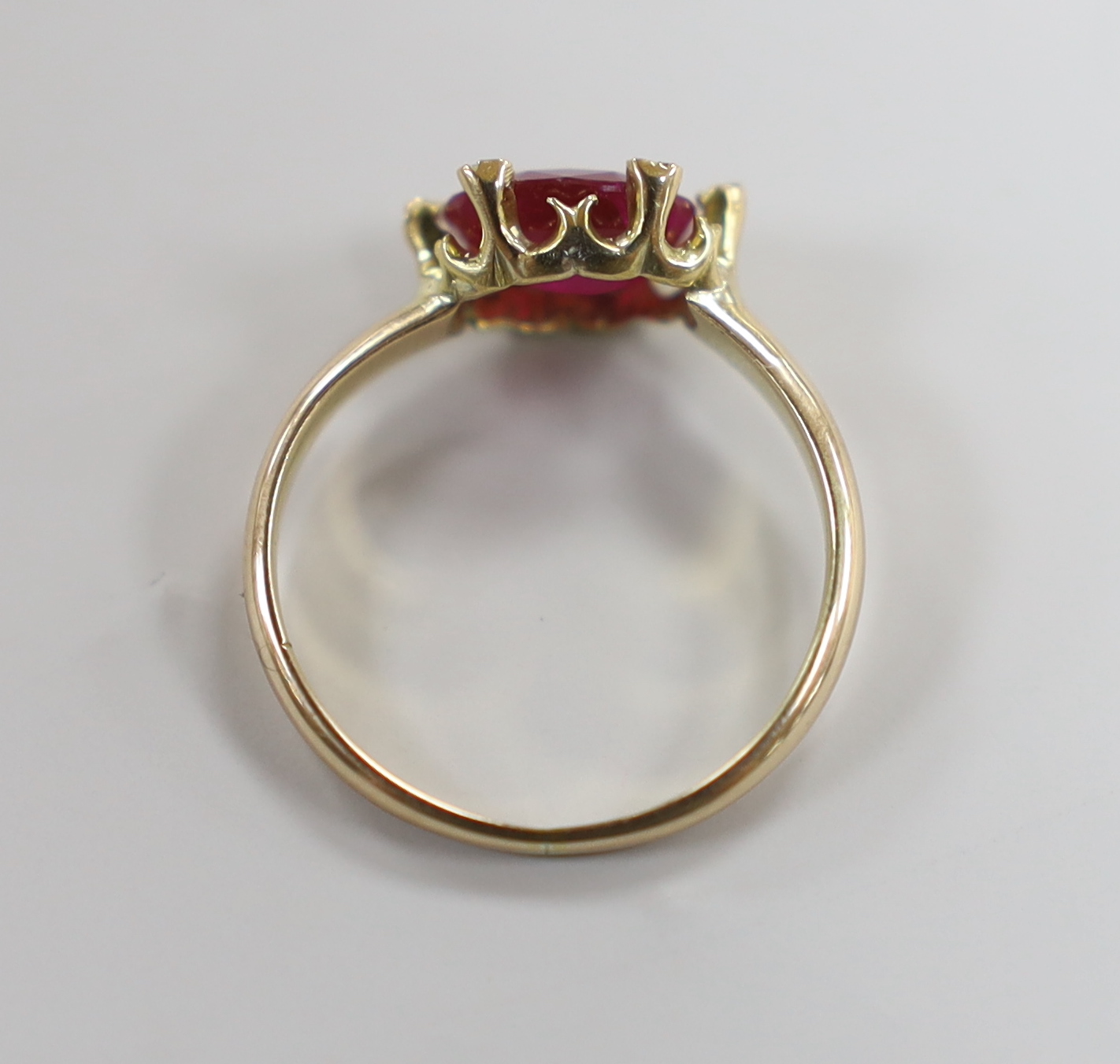 A yellow metal and single stone oval cut ruby and six stone diamond chip set ring, size L, gross weight 2.5 grams.